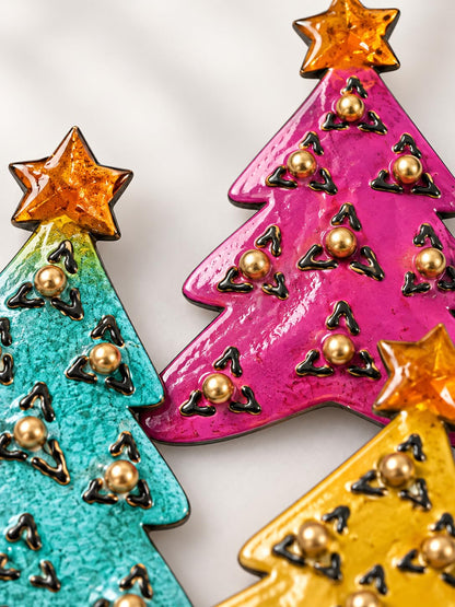 Detailansicht: Drei Weihnachtsbaum-Magnete aus Metall in Türkis, Pink und Gelb