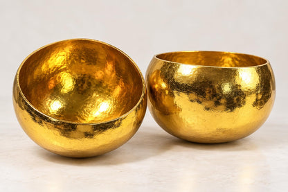 Zwei goldfarbene Kokosschalen schräg von oben