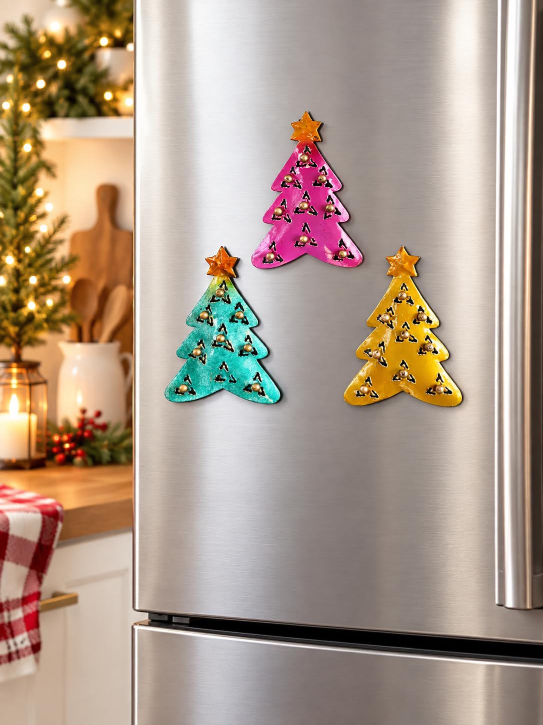 Drei bunte Weihnachtsbaum-Magnete an einer Kühlschranktür