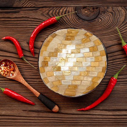 Draufsicht auf eine Perlmutt-Kokosschale zwischen Chilischoten und einem Holzlöffel