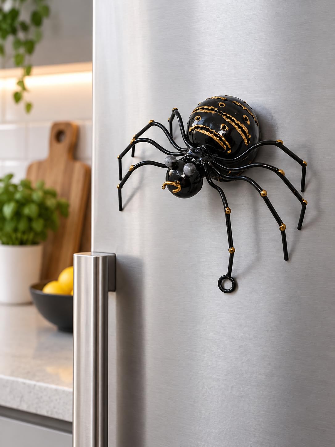 Schwarze Metallspinne an einer Kühlschranktür