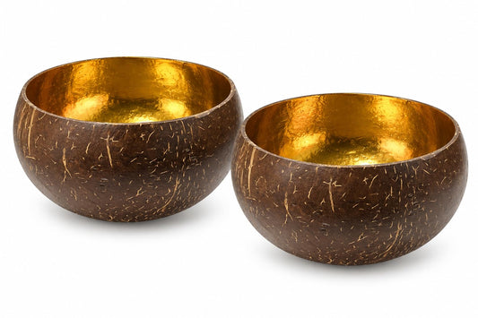 Zwei naturbraune Kokosschalen mit goldfarbener Innenseite