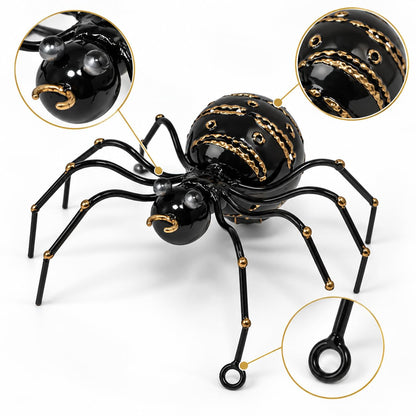 Detailansicht: Schwarze dekorative Metallspinne mit goldfarbenen Verzierungen