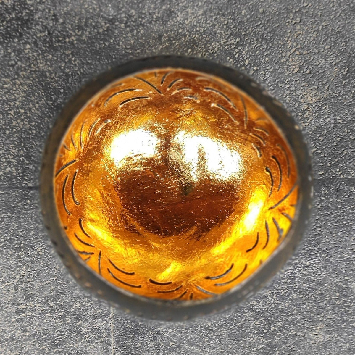 Blick in die goldfarbene Innenseite eines schwarzen Kokosschalen-Windlichts