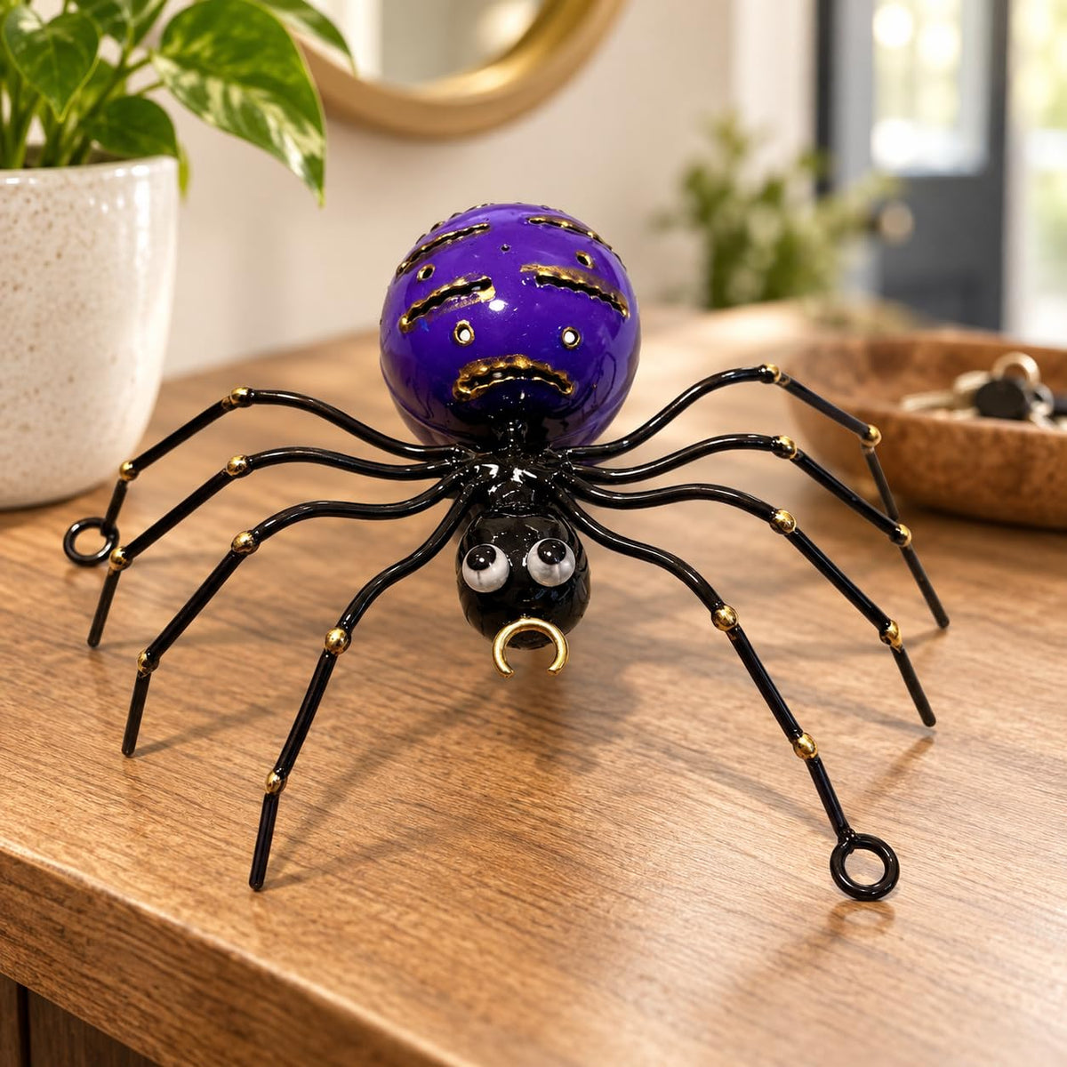 Dekorations- oder Anwendungsbeispiel: Violette dekorative Metallspinne mit schwarzen Beinen und goldfarbenen Details
