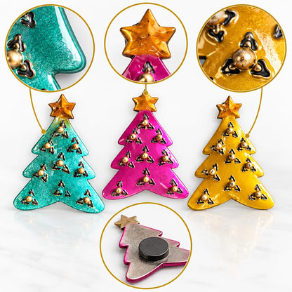 Detailansicht: Drei Weihnachtsbaum-Magnete aus Metall in Türkis, Pink und Gelb