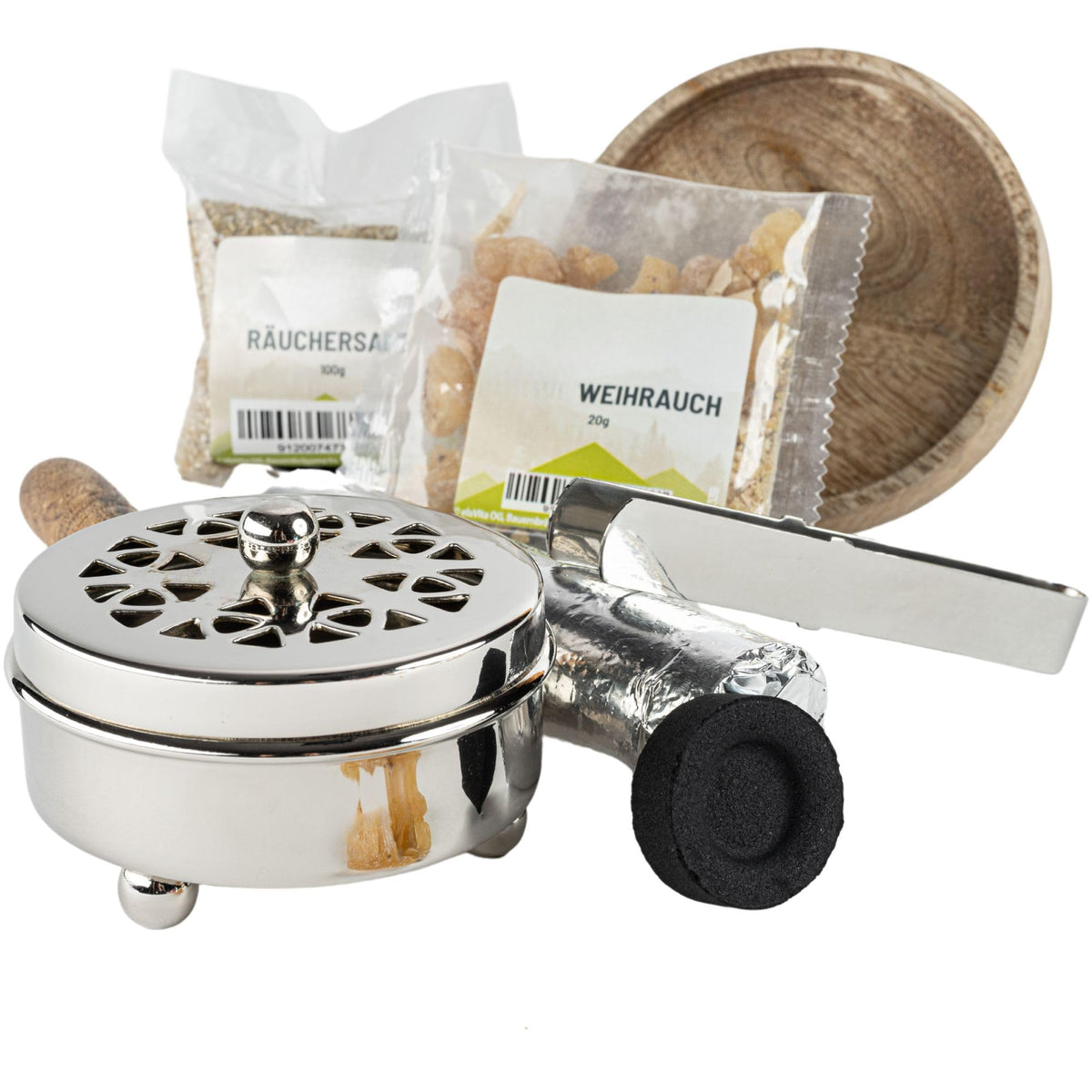Silberfarbene Räucherpfanne mit Holzgriff neben Räuchersand, Weihrauch, Zange und Kohle